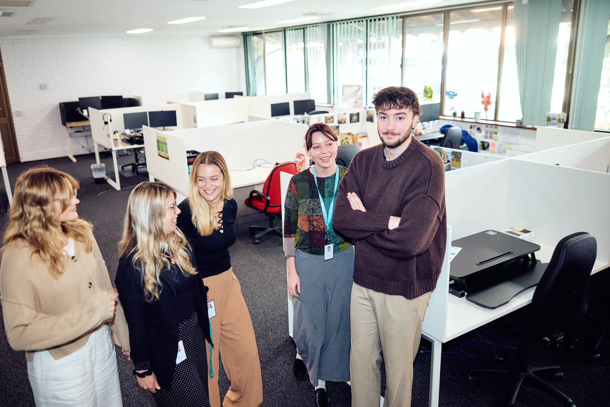 The Ability WA Customer Engagement team standing together in their open-plan office