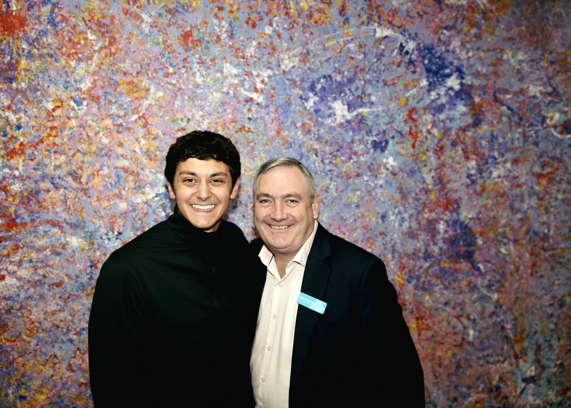 David Edwards of Ability WA standing with Keoki Alexander-Chang of Minikai in front of a colourful painted artwork